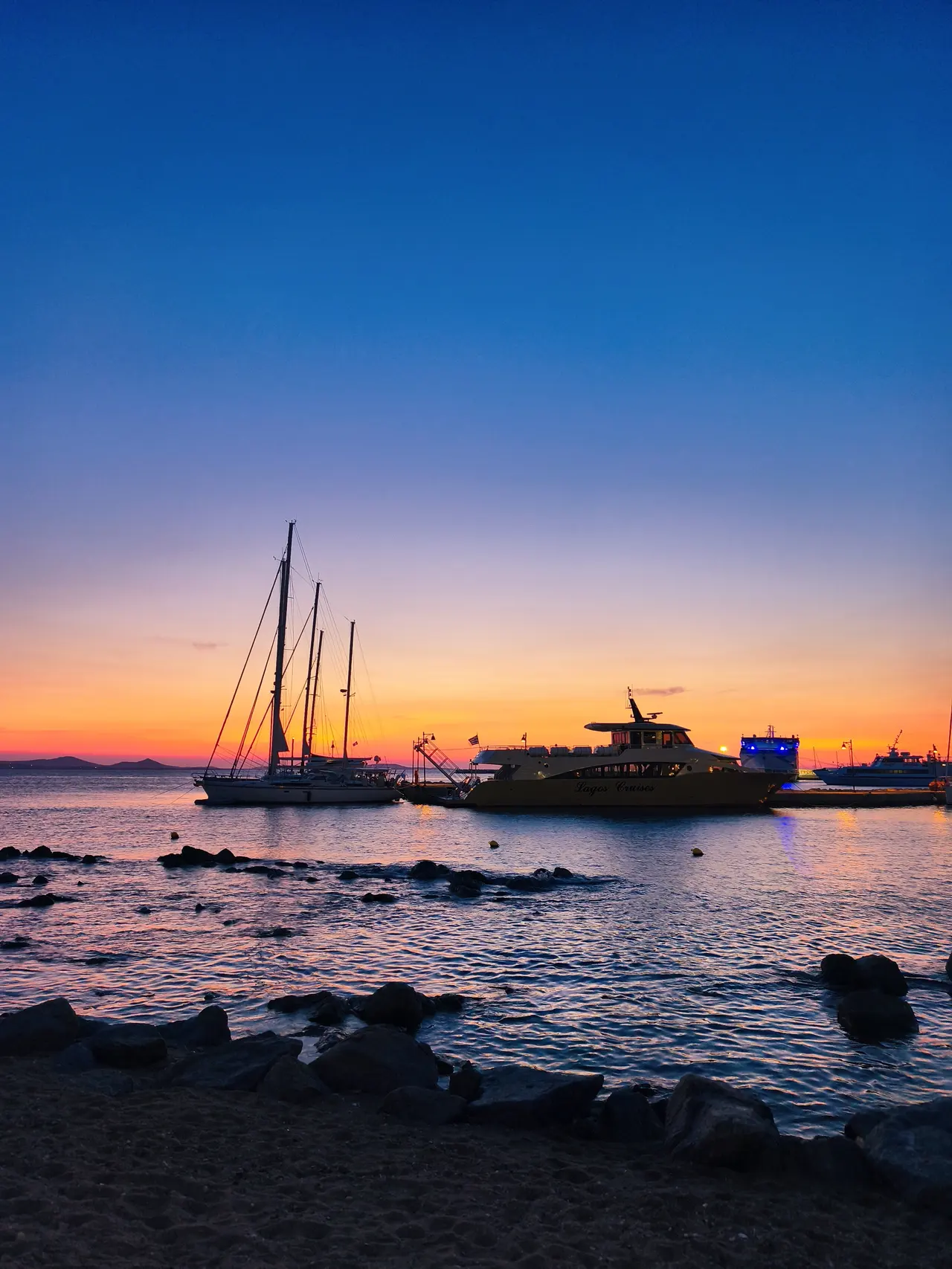 Sailing yachts in Naxos harbour at sunset