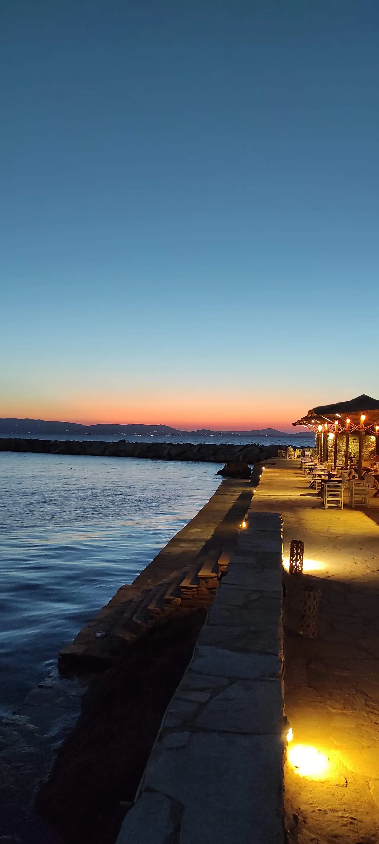 The stone quay and taverna at dusk
