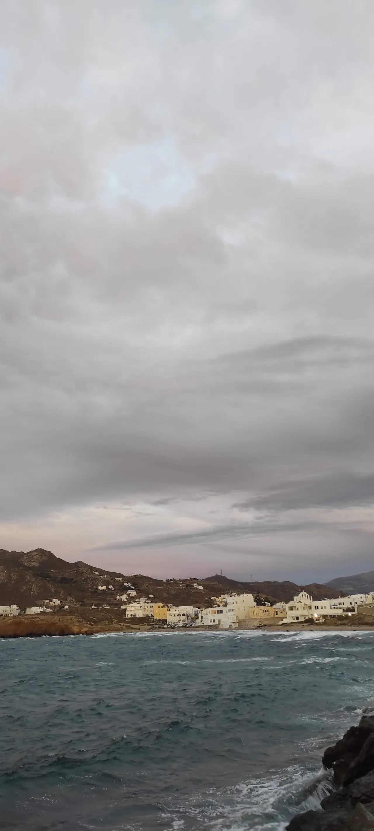 Village and rough sea under clouds